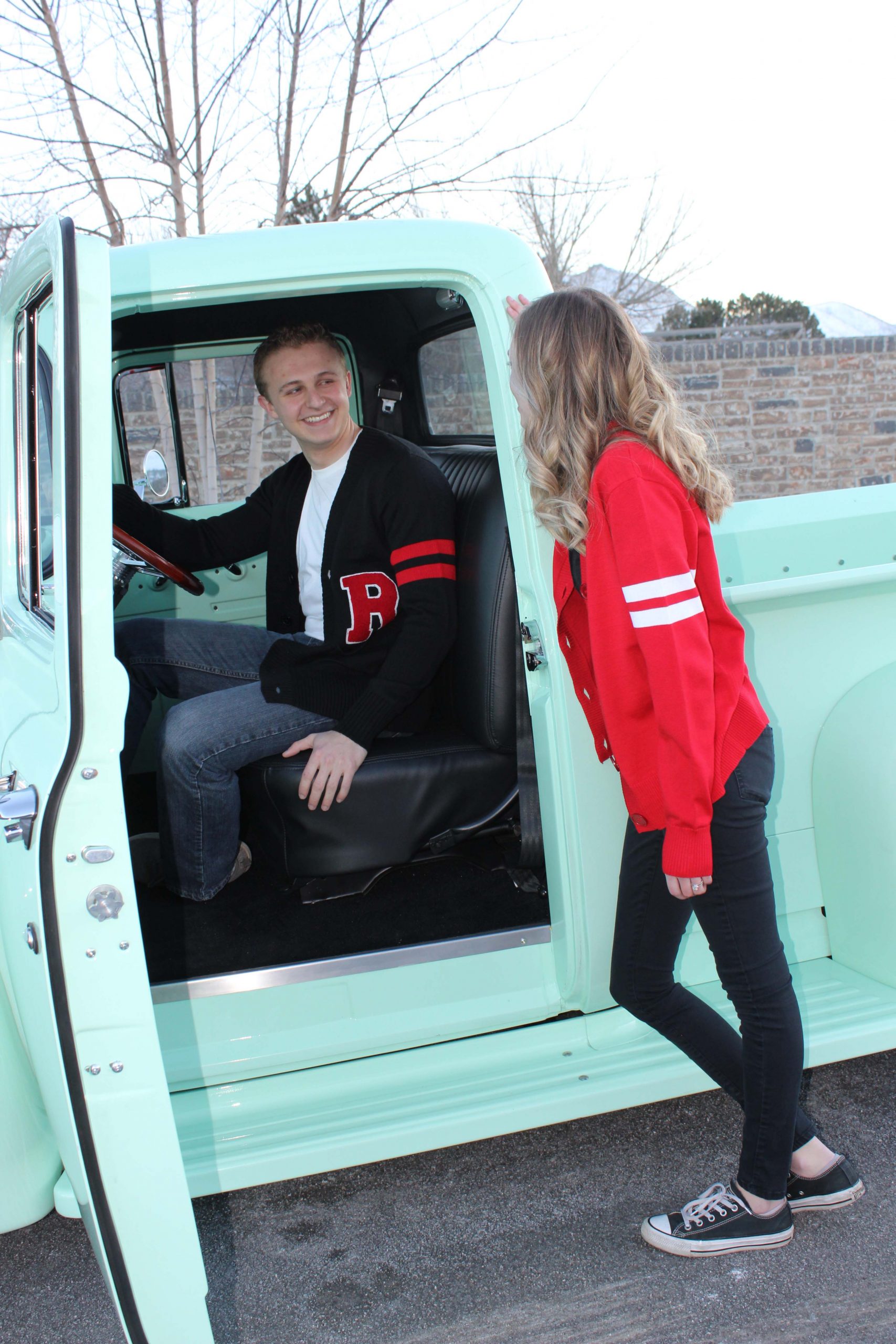 IMG_5022 WOO siblings male and female standing in front of a 1956 Ford F100 mint green truck modeling retro style letterman sweater in mens and womens designs in the USA