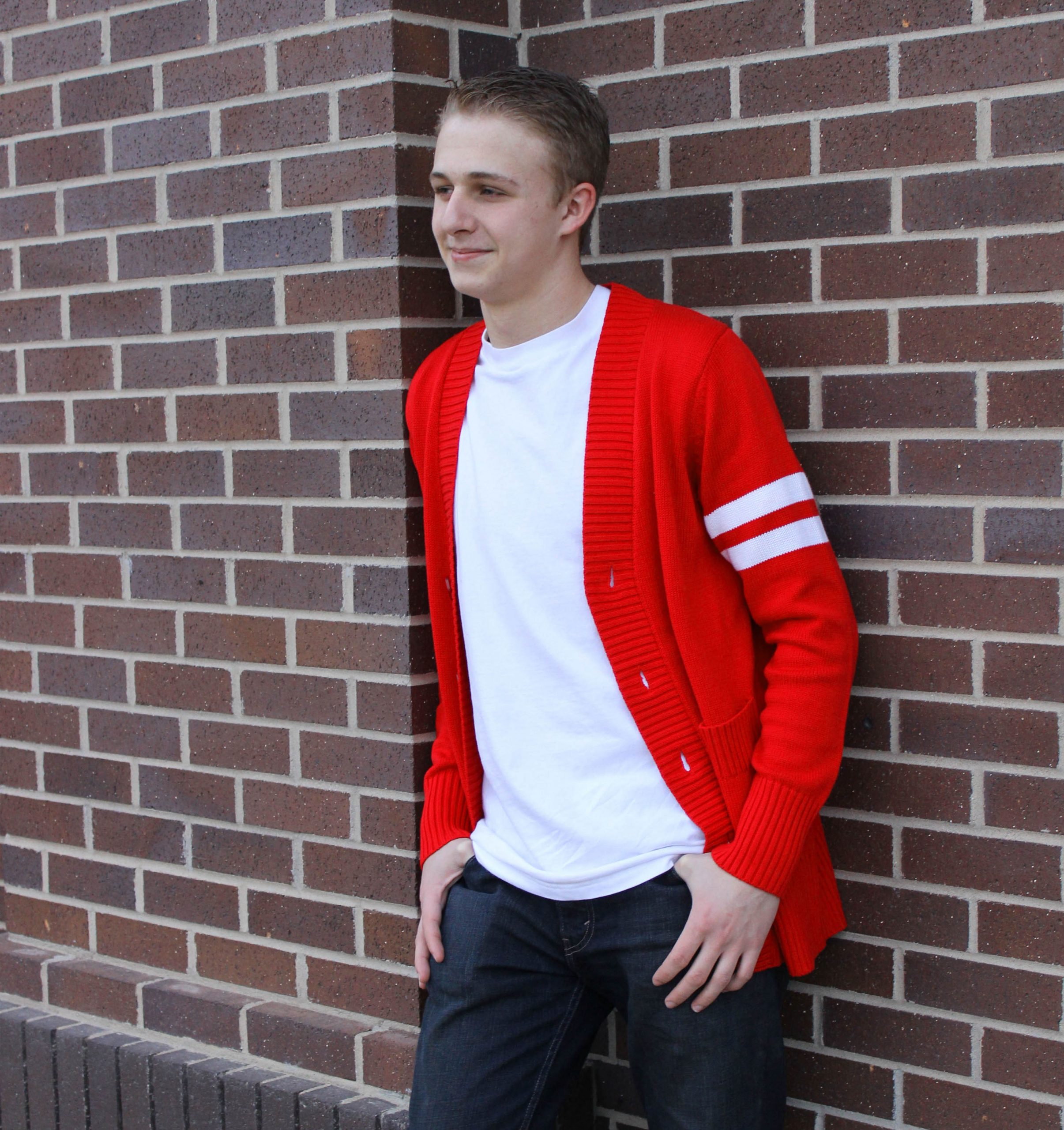 red sweater 1 WOO Male wearing a 1950's red varsity letterman sweater over a white t-shirt standing in front of a brick wall.