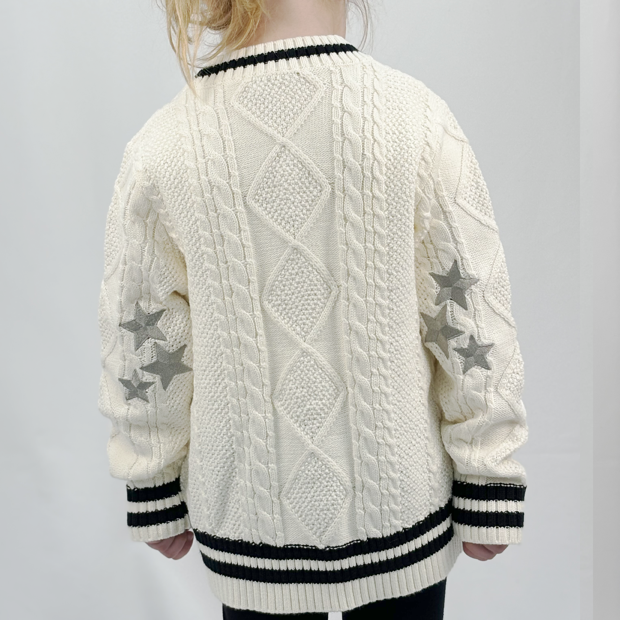 Back of Taylor Tot off-white cardigan sweater. Detail shows three silver embroidered starts on each elbow.