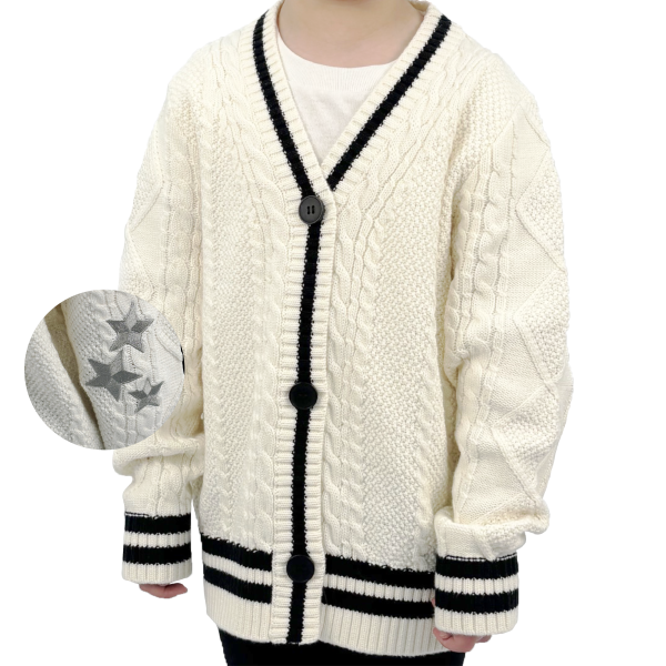Girl wearing a white cardigan with black stripe and stars on the elbow.