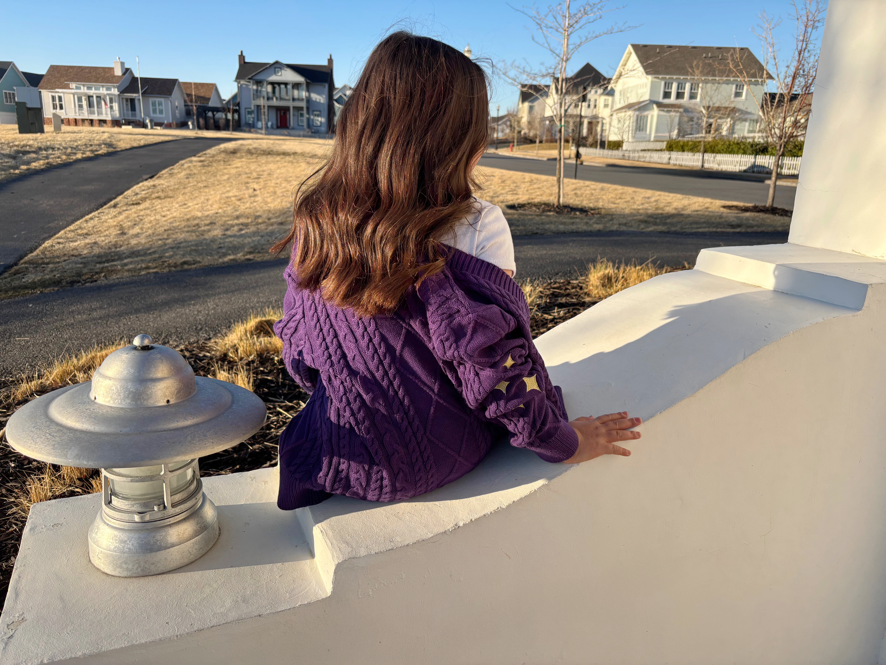 little girl wearing purple cardigan with gold sparkles on the sleeves