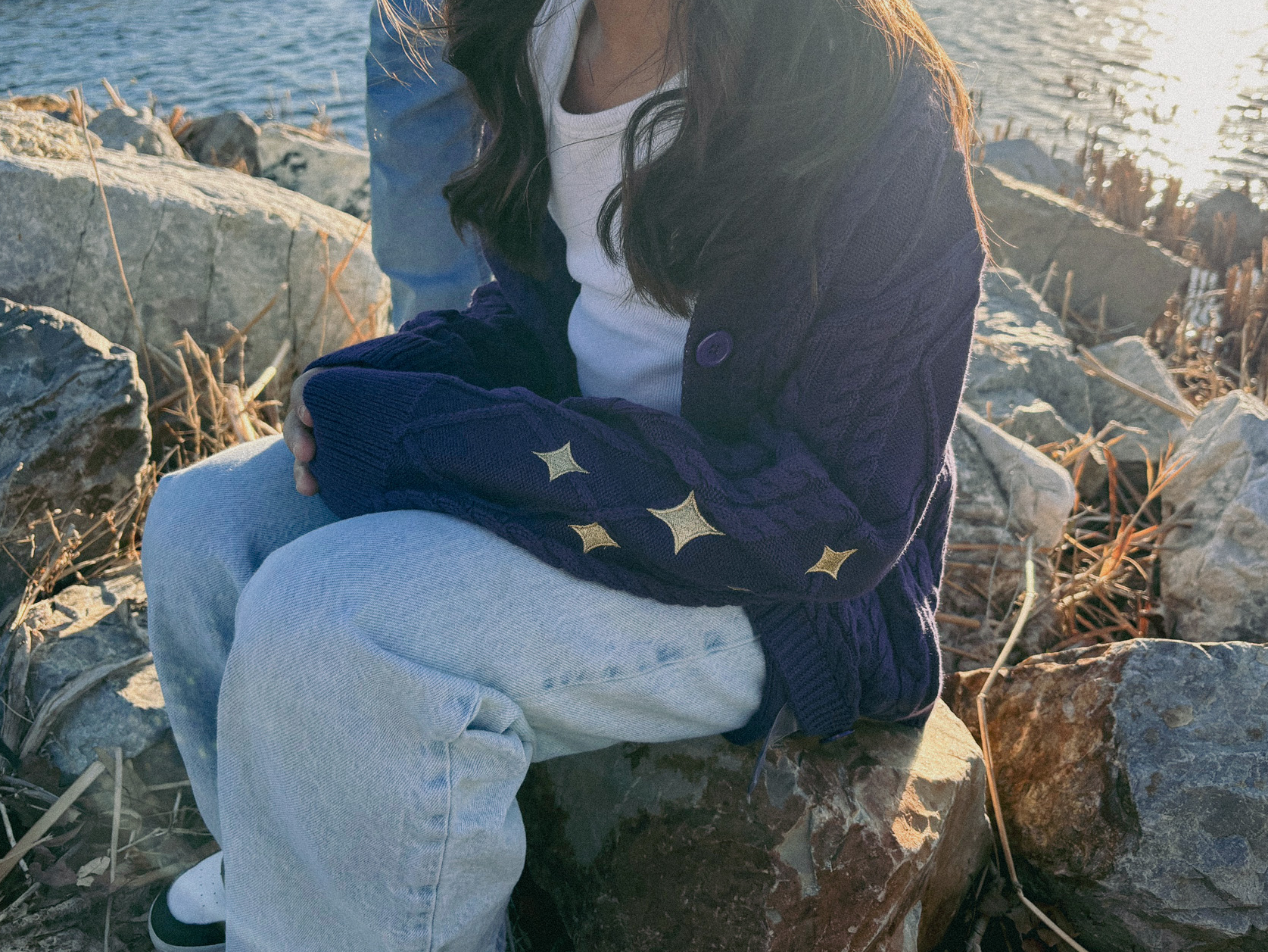 little girl wearing purple cardigan with gold sparkles on the sleeves